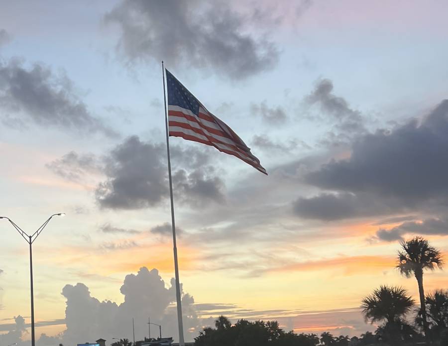Cape Coral's 250-foot flagpole flying its flag again at sunset in Bernice Braden Park after repairs
